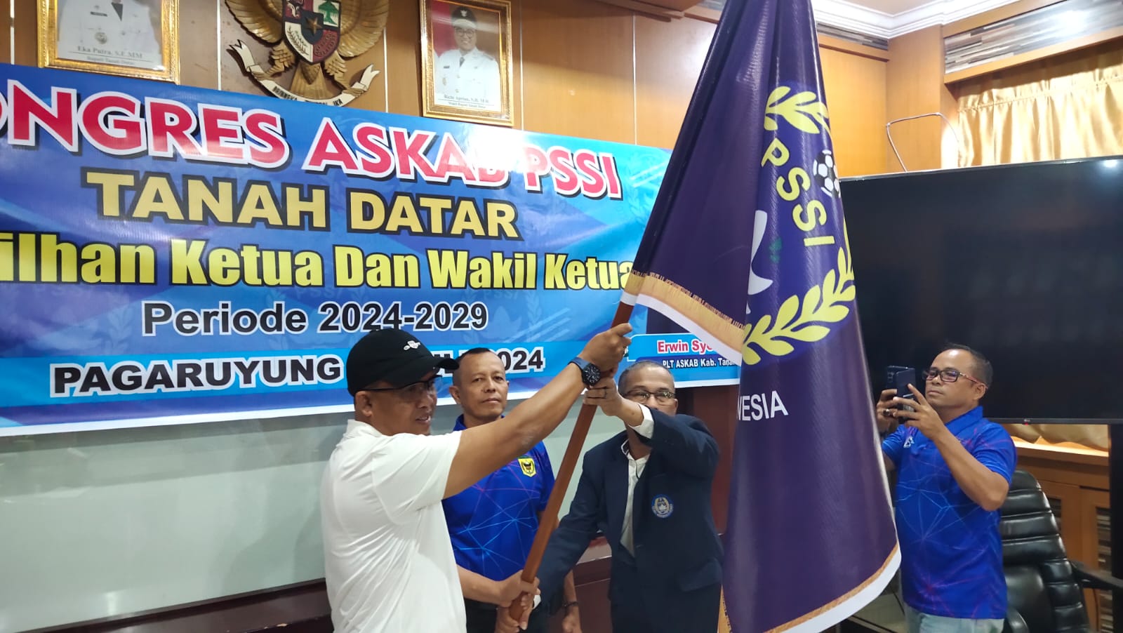 Ketua Askab PS Tanah Datar terpilih Wel Ahmad menerima pataka Ketua Asprov Erwin Syofyan untuk dikibarkan